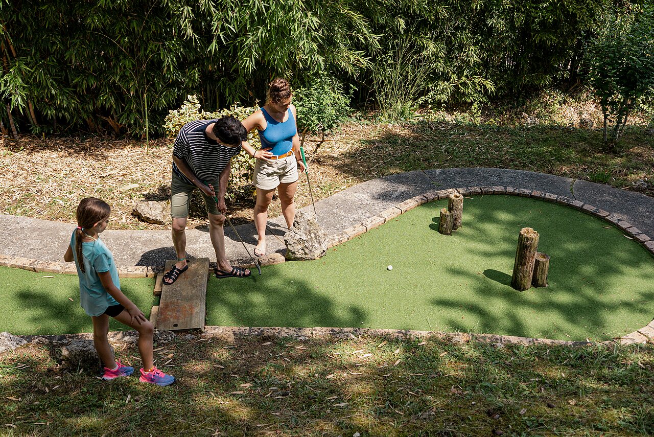 Famille jouant au mini-golf sur un parcours ext�rieur au camping CAPFUN Lac des 3 Vall�es � Lectoure (32).