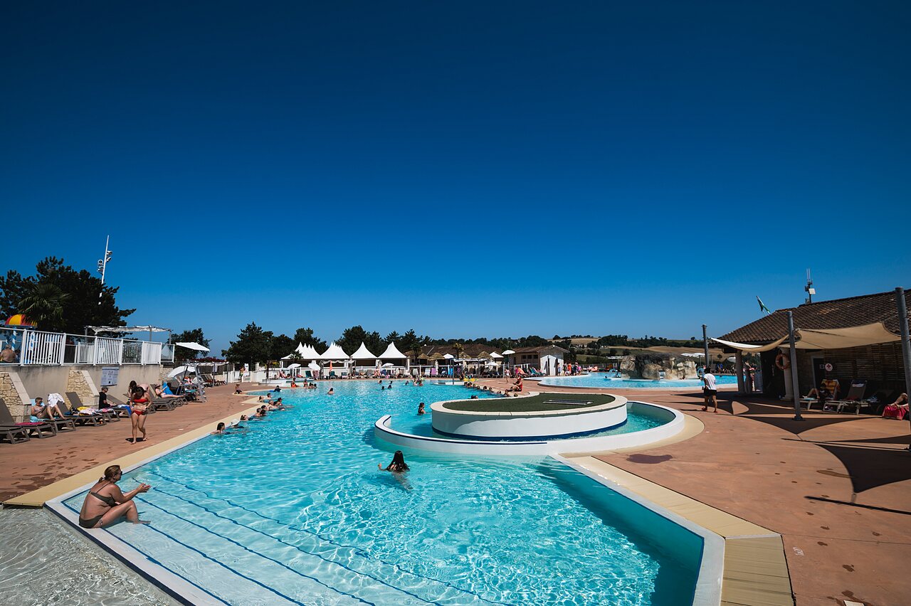 Grande piscine ext�rieure avec baigneurs et bar au camping CAPFUN Lac des 3 Vall�es � Lectoure (32).