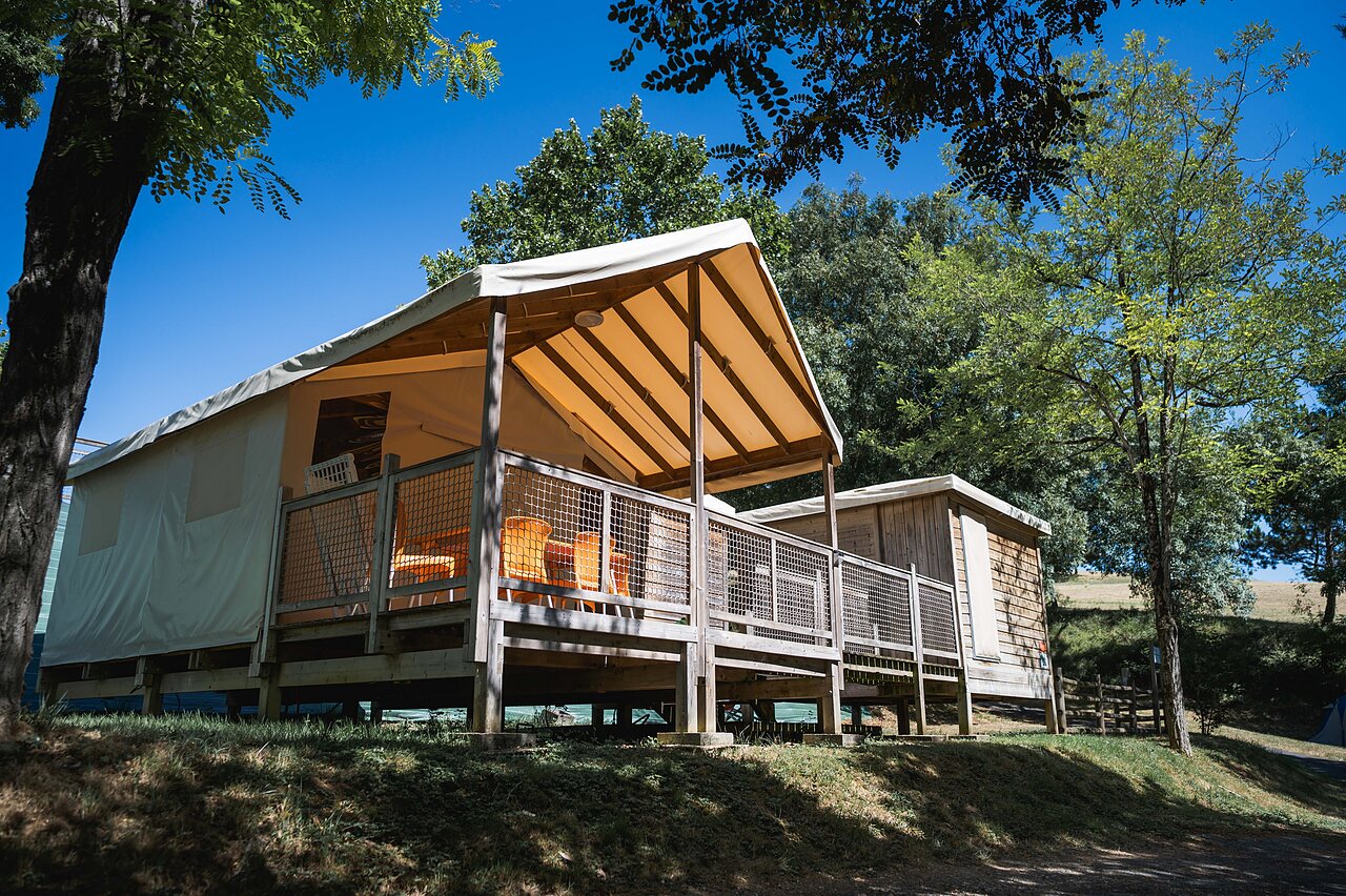 Tente �quip�e avec terrasse en bois, arbres, au camping CAPFUN Lac des 3 Vall�es � Lectoure.