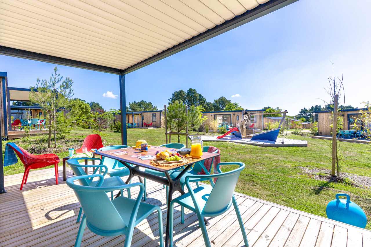 Terrasse couverte d'un mobil-home, aire de jeux enfants au camping CAPFUN Lac de Ribou � Cholet (49).