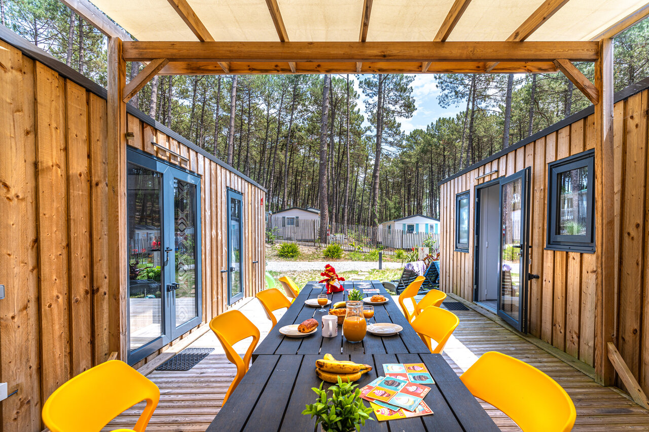 Terrasse am�nag�e avec table de petit-d�jeuner devant mobile-homes au camping CAPFUN Landisland � Moliets-et-Maa (40).