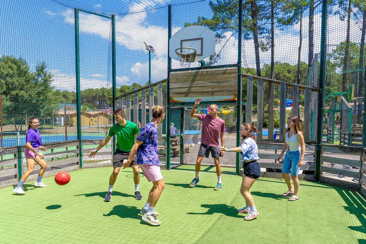 Jeunes jouant au basketball sur terrain multisport au camping CAPFUN Landisland � Moliets-et-Maa.