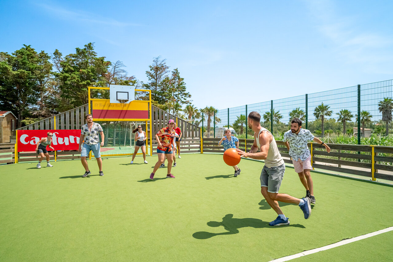 Terrain multisport avec jeunes jouant au basketball au camping CAPFUN Las Bousigues � Le Barcar�s (66).
