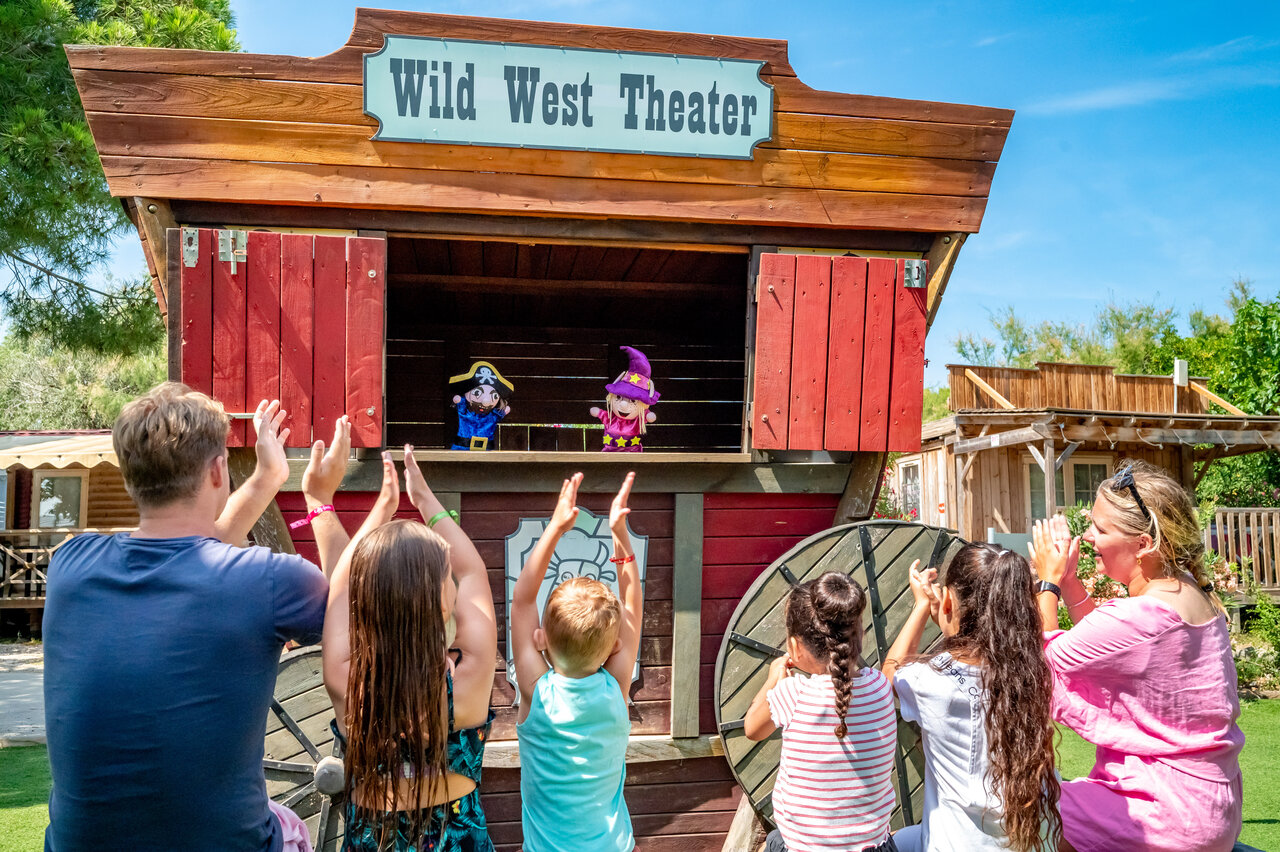 Spectacle de marionnettes au Wild West Theater, famille applaudissant au camping CAPFUN Las Bousigues � Le Barcar�s (66).