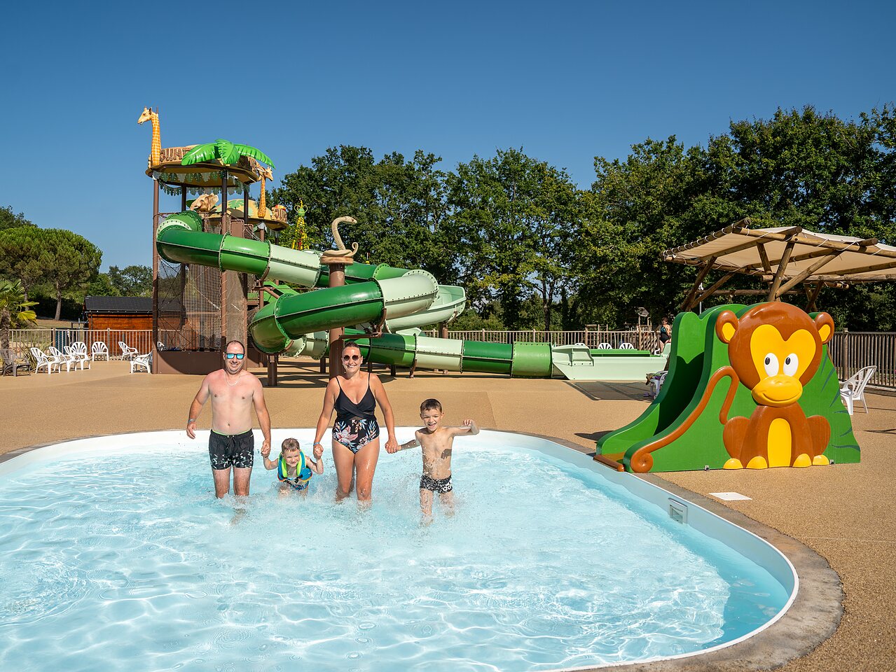 Famille profitant de la piscine, toboggans et jeux aquatiques au camping CLICOCHIC Les Secrets de Padirac � Padirac (46).