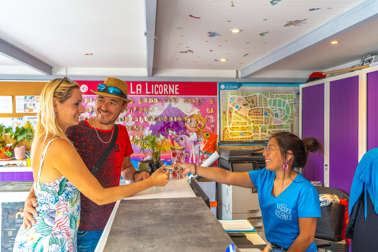 Couple recevant les cl�s � la r�ception du camping VAGUES OCEANES Licorne.