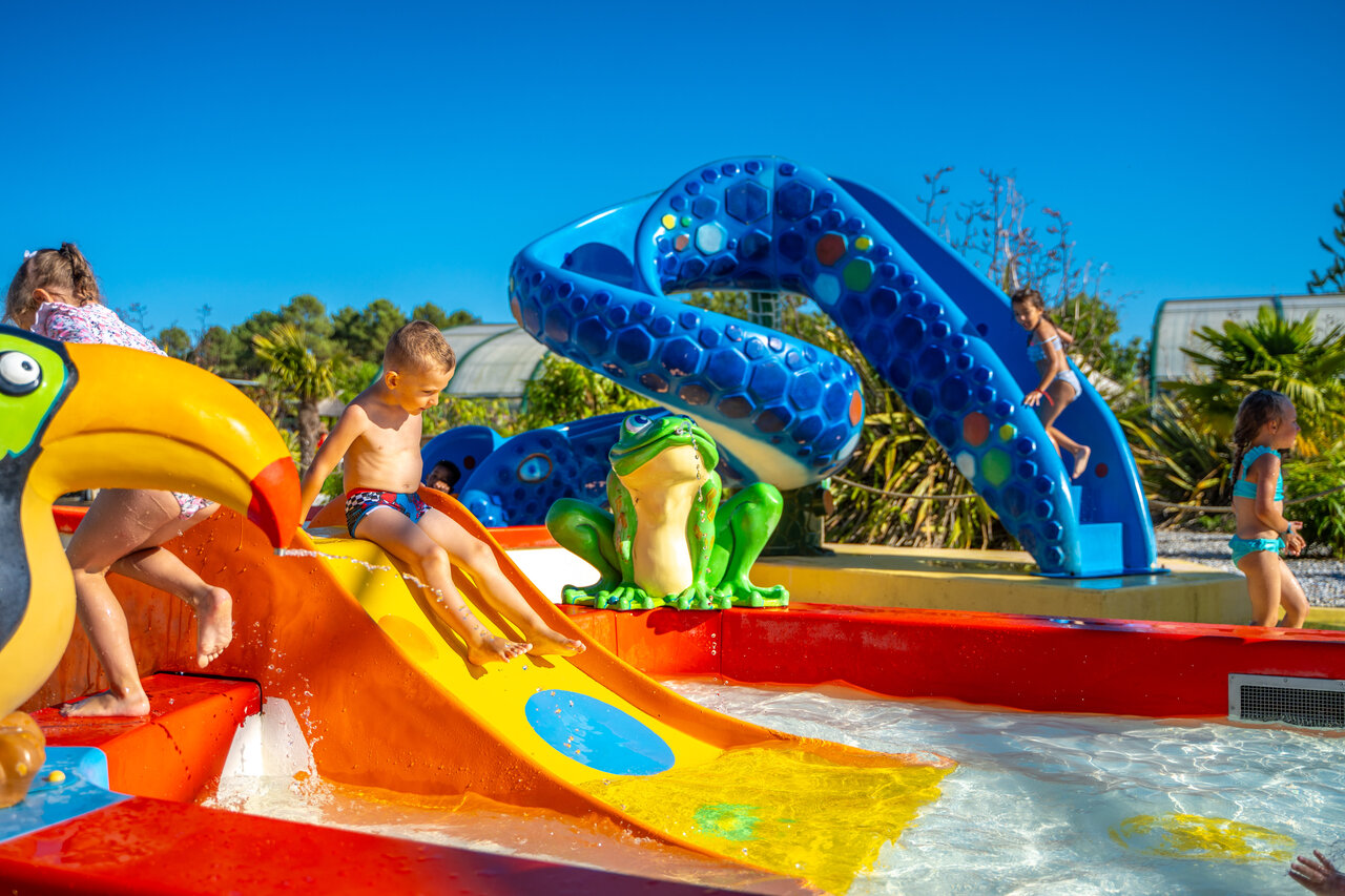 Enfants jouant sur toboggans color�s et jeux d'eau, pataugeoire au camping CAPFUN Lila � LINXE (40).