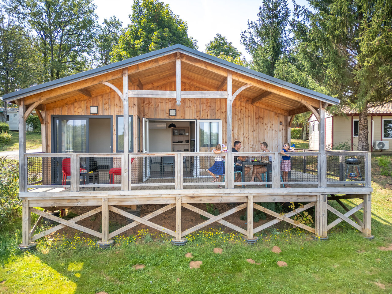 Chalet en bois avec terrasse et famille au camping CLICOCHIC Linotte � Le Bugue (24).