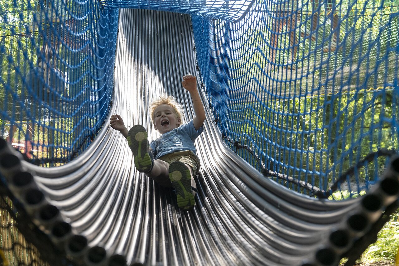Enfant souriant sur toboggan tubulaire bleu au camping CAPFUN Lodge � SARZEAU (56).
