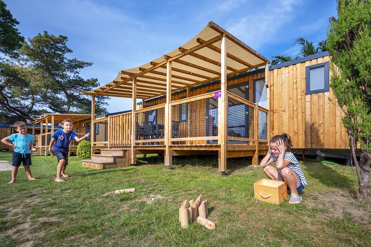 Enfants jouant devant des mobile-homes modernes au camping CLICOCHIC Longchamp � Saint Lunaire (35).