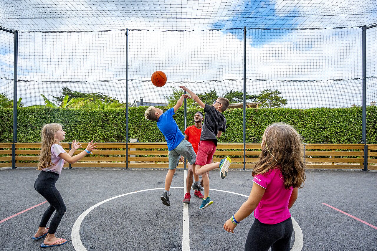 Enfants jouant au basketball sur terrain multisport au camping CLICOCHIC Longchamp � Saint Lunaire (35).
