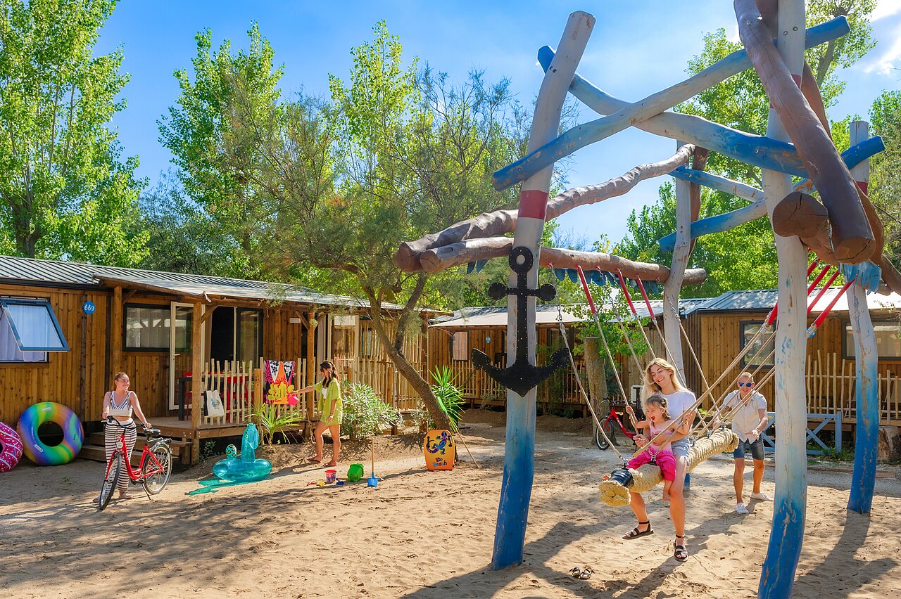 Aire de jeux avec balan�oire et Mobil-homes au camping CAPFUN Lou Village � Vendres (34).