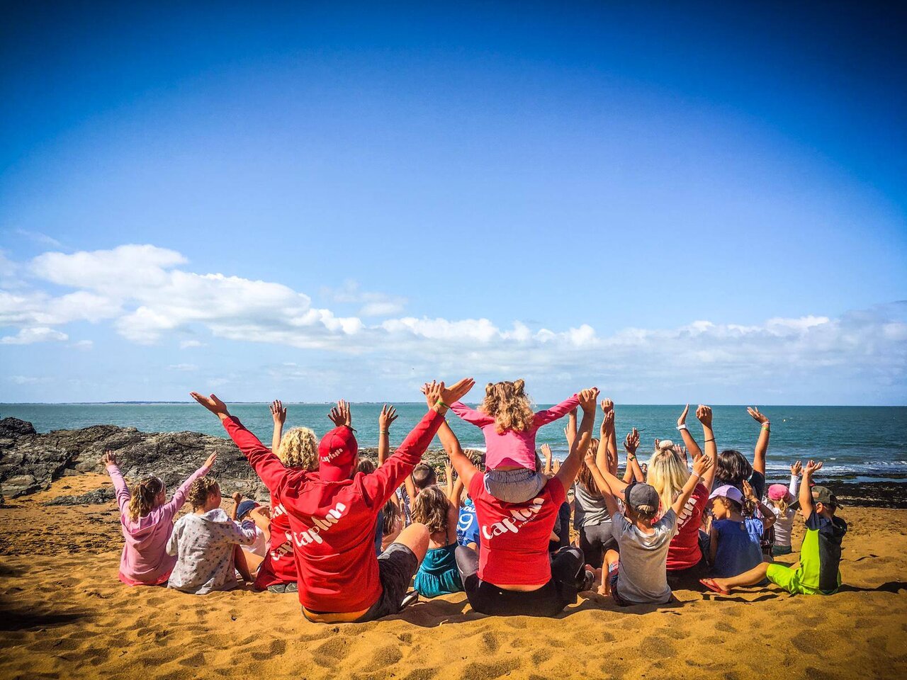Enfants et animateurs Capfun sur la plage, bras lev�s, au camping CAPFUN Madrague.