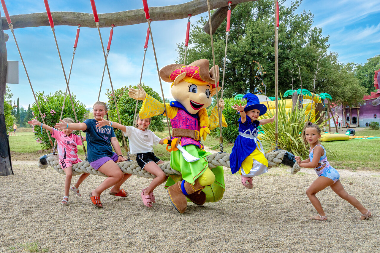 Enfants et mascotte sur balan�oire g�ante, aire de jeux CAPFUN Mael, ARGELES SUR MER.