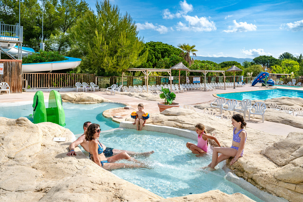 Famille profitant de la piscine ludique avec toboggan au camping CAPFUN Malissonne � LA CADIERE D'AZUR (83).