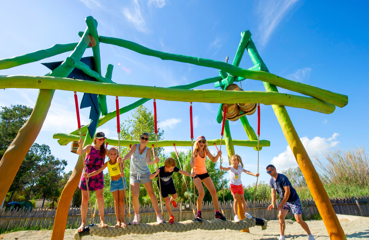 Famille s'amusant sur l'aire de jeux au camping CAPFUN Marina d'Al�ria � Aleria (20).