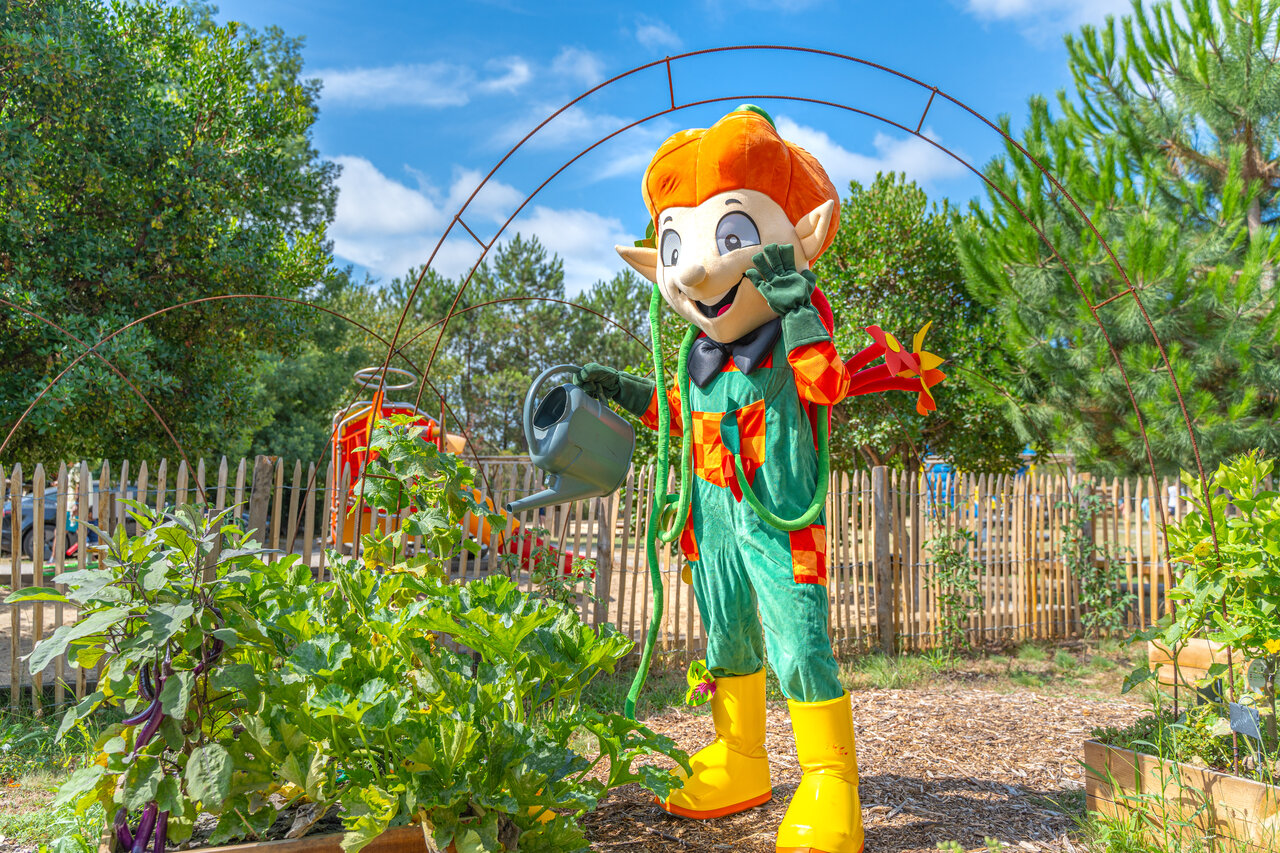 Mascotte jardinier arrosant des plantes dans le potager au camping CLICOCHIC M�doc Bleu � Carcans (33).