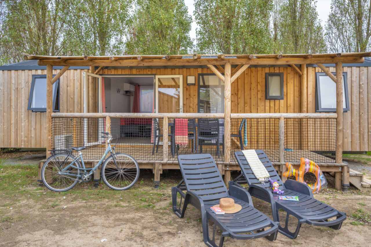 Mobil-home en bois, terrasse am�nag�e, transats, v�lo au camping CLICOCHIC M�doc Bleu.