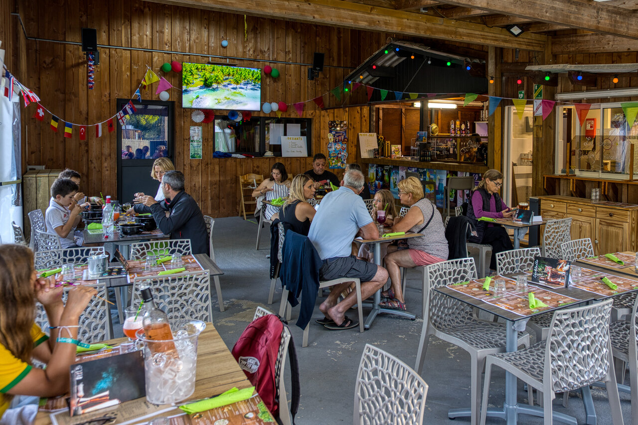 Familles et amis d�nant au restaurant-bar du camping CLICOCHIC M�doc Bleu � Carcans (33).