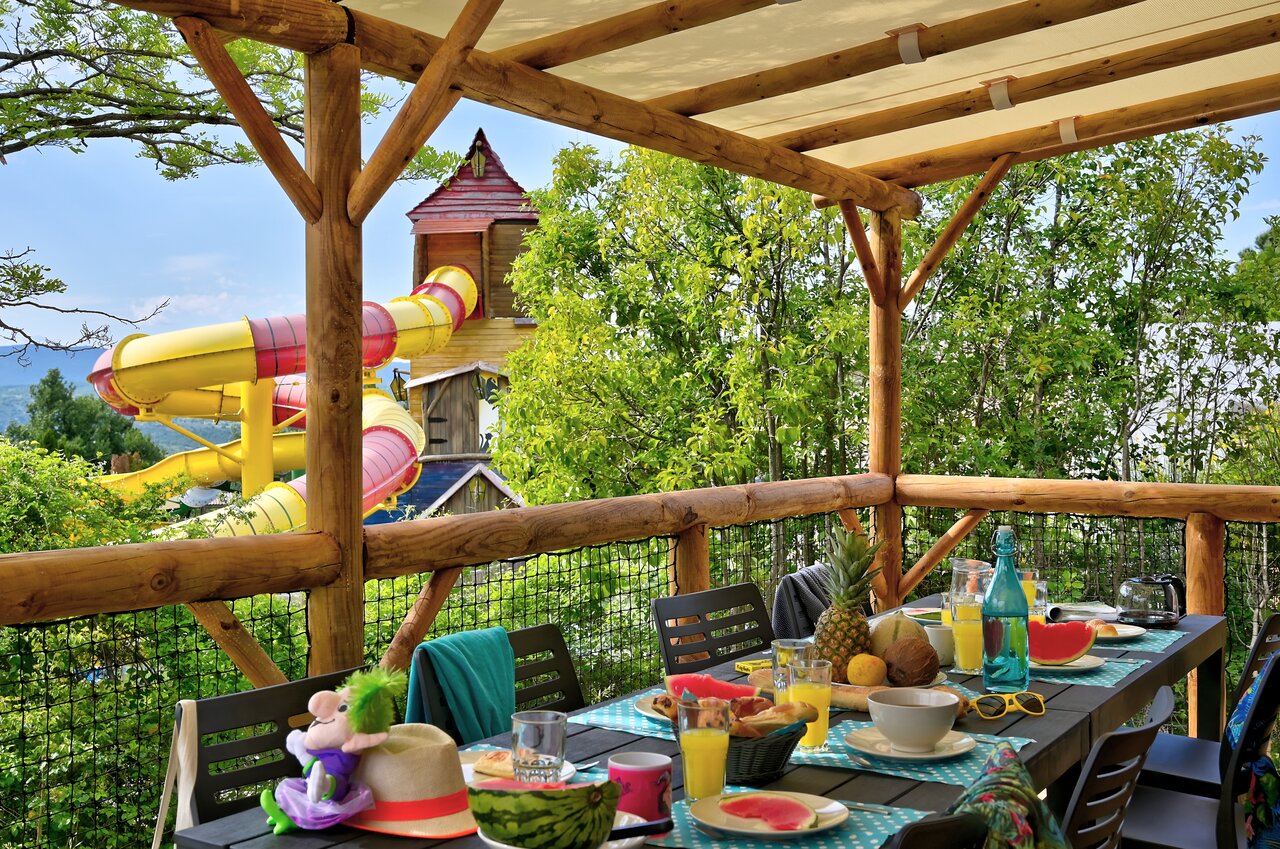 Terrasse ombrag�e, repas et toboggan aquatique au camping CAPFUN Merle Roux � Baix.