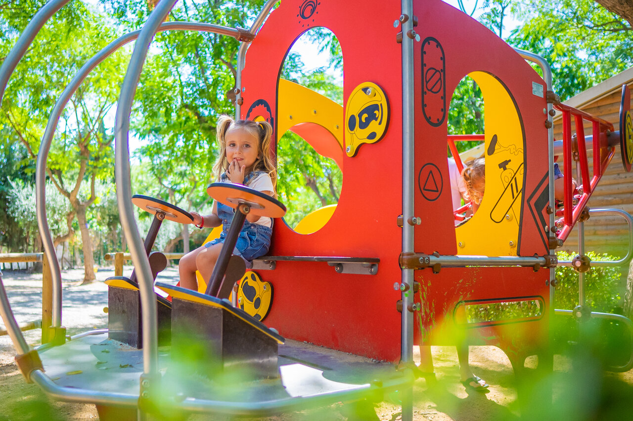Enfant sur man�ge color� aire de jeux au camping CAPFUN Mirmanda � Cambrils.