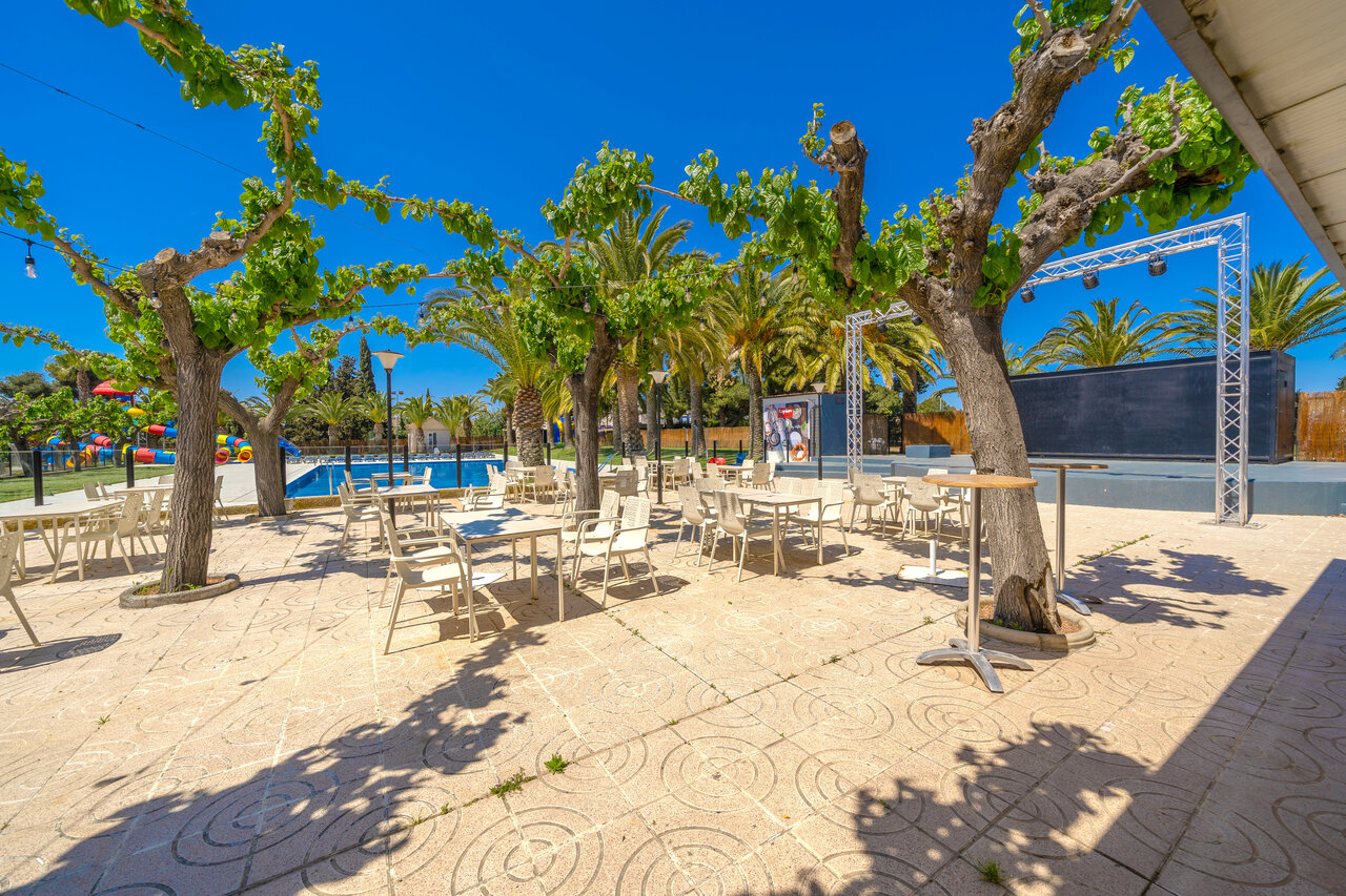Terrasse de restaurant ombrag�e, piscine et sc�ne au camping CAPFUN Mirmanda � Cambrils.