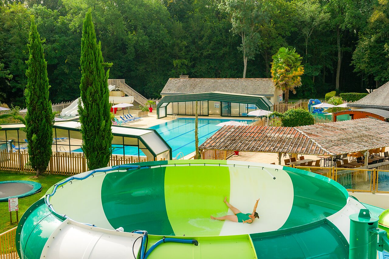 Femme sur toboggan aquatique g�ant, piscines et verdure au camping CAPFUN Montsabert � COUTURES (49).