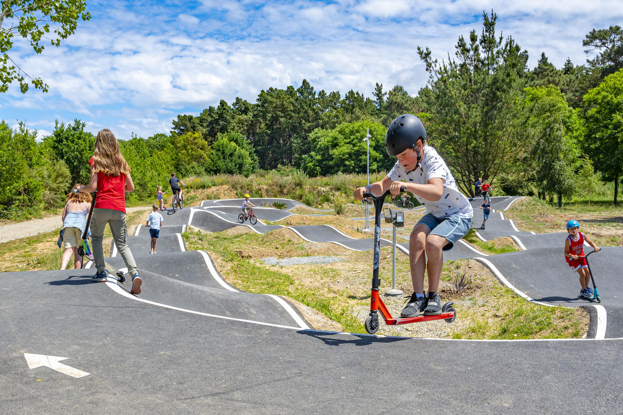 Enfants sur pump track avec trottinettes et v�los au camping CAPFUN Montblanc Park � Montblanc (43).