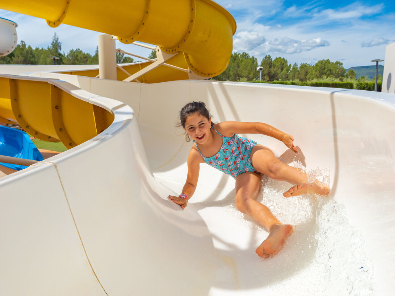 Enfant souriante sur toboggan aquatique au camping CAPFUN Montblanc Park � Montblanc (43).