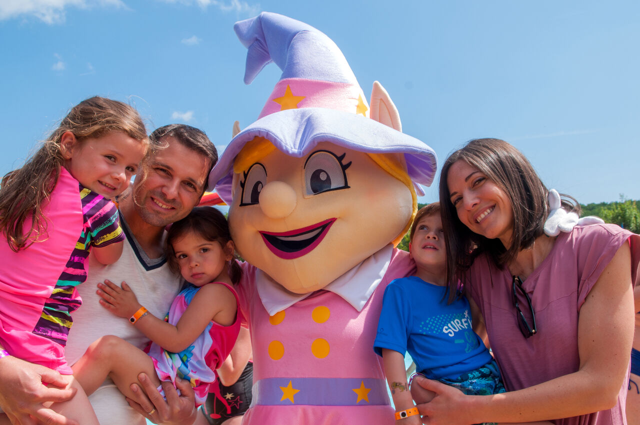 Famille souriante avec mascotte de camping, moment joyeux au CAPFUN Montblanc Park � Montblanc (43).