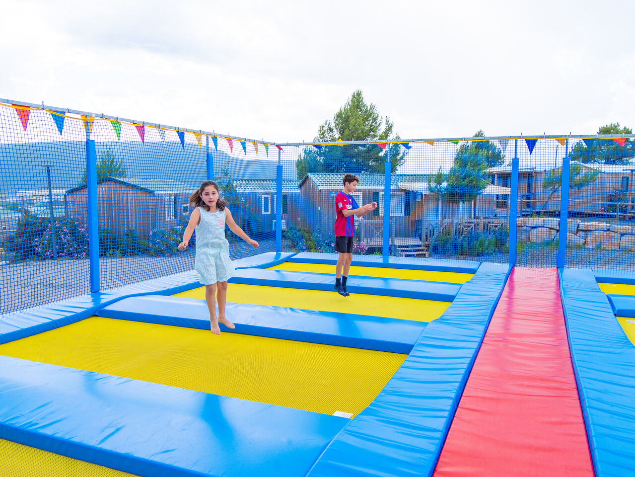 Enfants s'amusant sur trampolines, Mobil-homes en arri�re-plan au camping CAPFUN Montblanc Park � Montblanc (43).