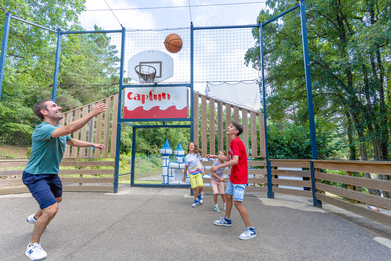 Famille jouant basketball sur terrain multisport au camping CAPFUN Moulinal � BIRON (24).