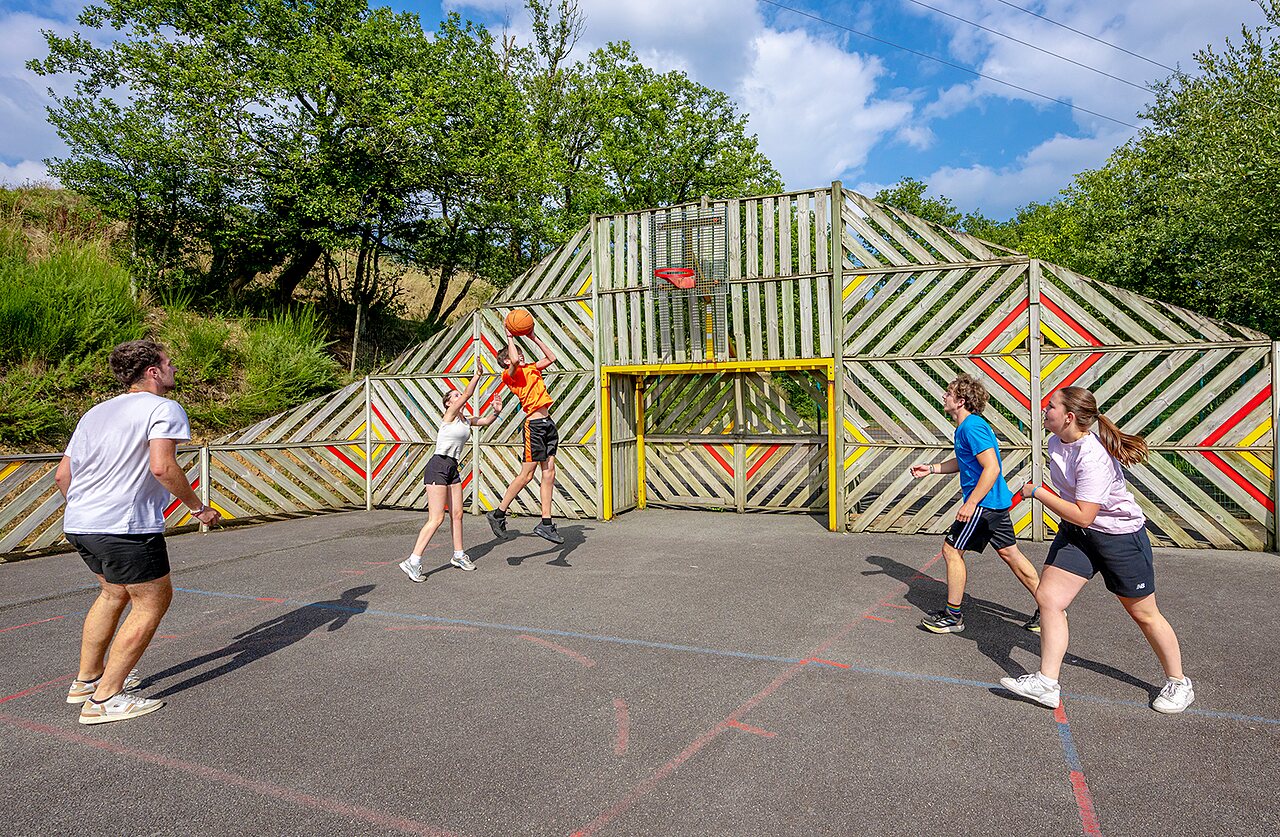 Terrain multisport avec jeunes jouant au basketball au camping VAGUES OCEANES Moulin de Cadillac � Noyal-Muzillac (56).