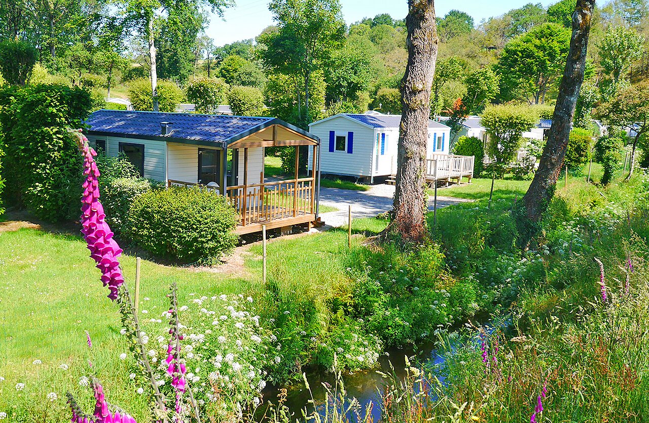 Mobil-homes avec terrasses en bois et ruisseau au camping VAGUES OCEANES Moulin de Cadillac � Noyal-Muzillac (56).