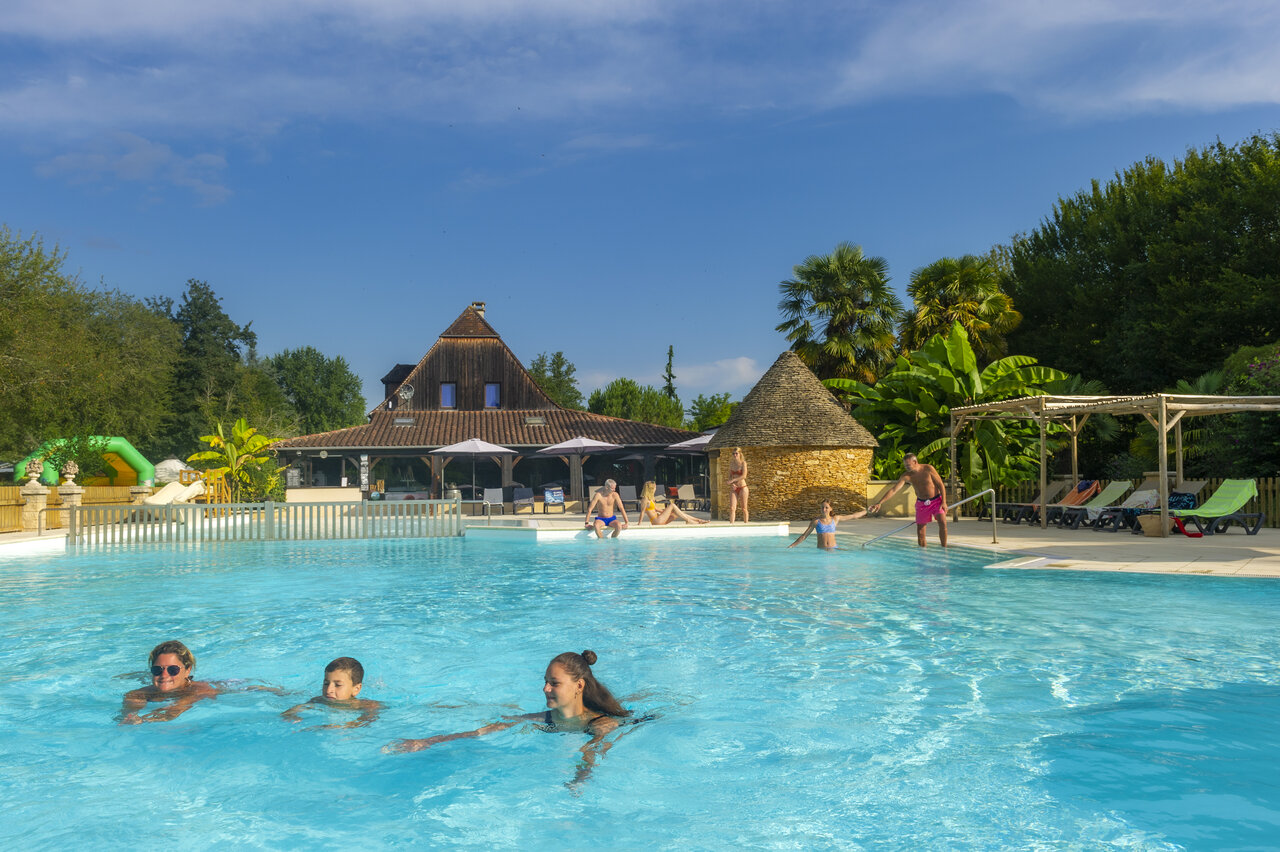 Piscine ext�rieure familiale, b�timent principal et jeux, au camping CLICOCHIC Moulin du Roch.