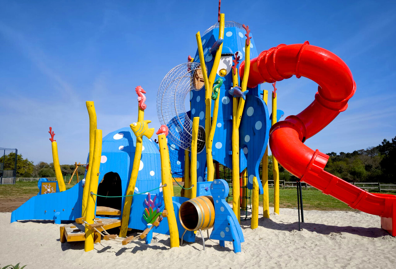 Aire de jeux th�me marin, toboggan rouge, structures bleues au camping VAGUES OCEANES Moustoir.