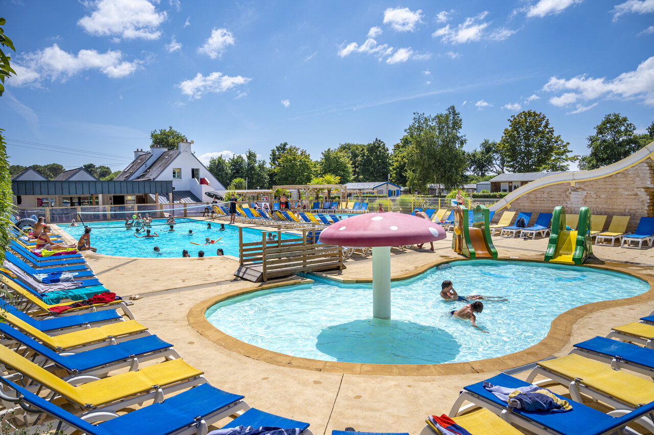 Piscine ext�rieure avec toboggans, champignon aquatique et transats au camping VAGUES OCEANES Moustoir � Carnac (56).