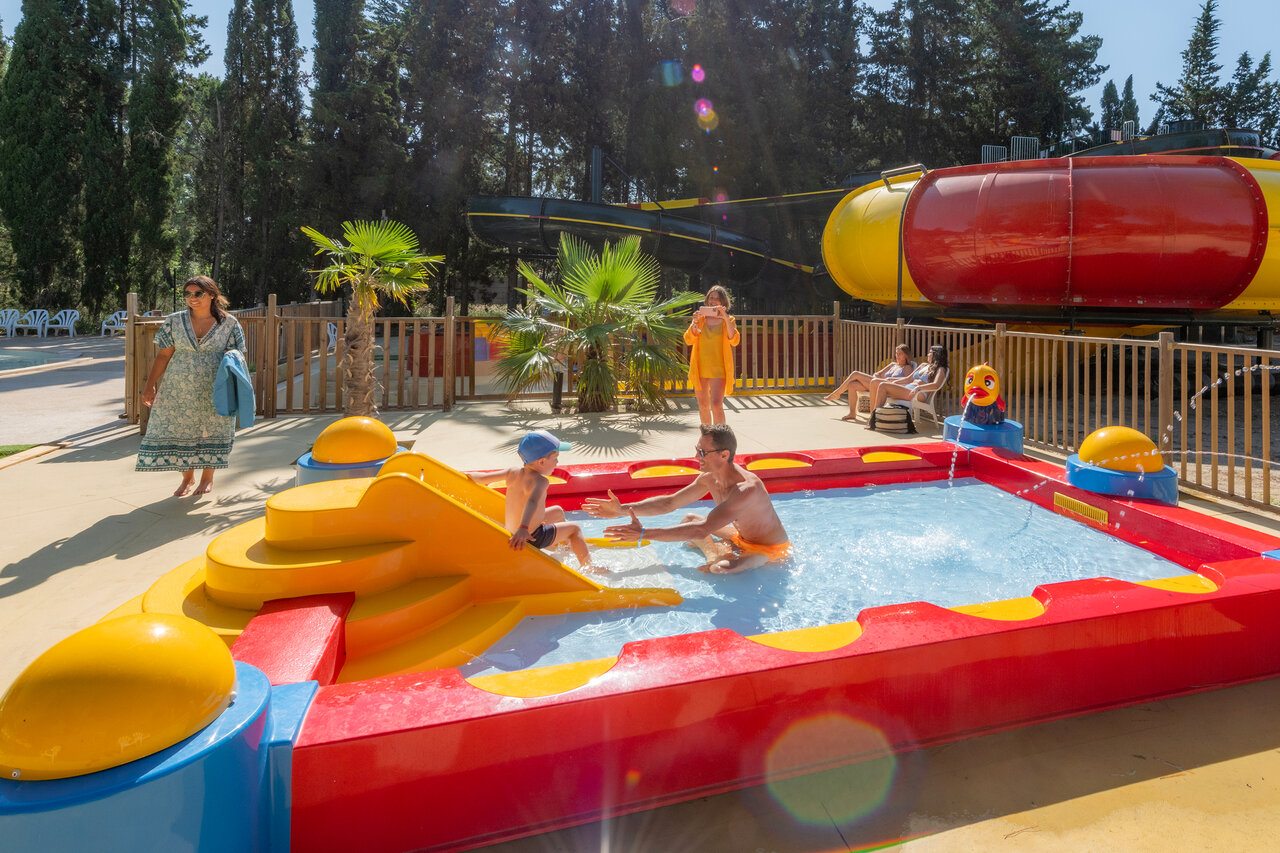 Pataugeoire color�e avec toboggan, p�re et enfant, au camping CAPFUN Or � La Grande Motte (34).