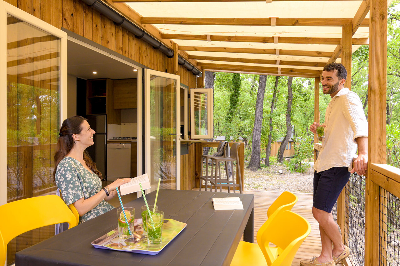 Mobil-home avec couple sur terrasse au camping CLICOCHIC Or�e d'Azur � OPIO.