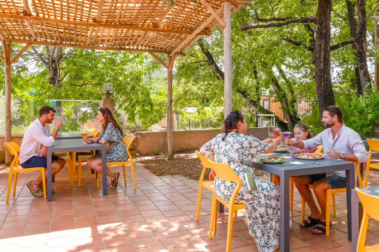 Familles d�jeunant en terrasse ombrag�e du restaurant au camping CLICOCHIC Or�e d'Azur � OPIO (06).