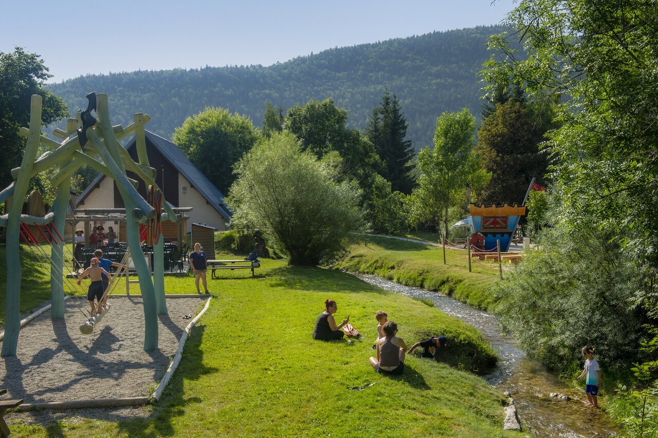 Aire de jeux enfants, ruisseau et verdure au camping CAPFUN Oursi�re � Villard de Lans (38).