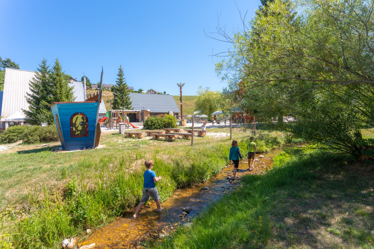 Enfants jouant dans ruisseau, aire de jeux au camping CAPFUN Oursi�re � Villard de Lans.