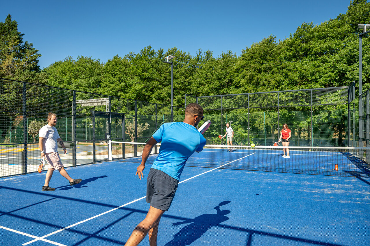 Court de padel bleu avec quatre personnes jouant au camping CAPFUN Pachacaid � La Mole (83).