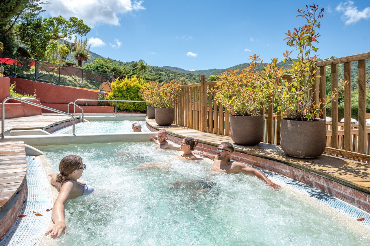 Famille profitant du jacuzzi ext�rieur et de la piscine au camping CAPFUN Pachacaid � La Mole (83).
