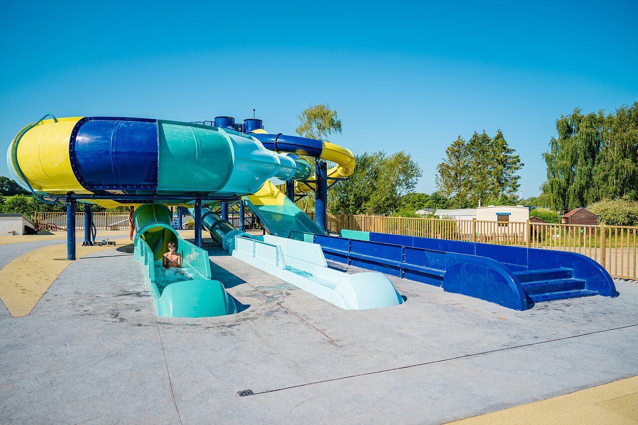 Colorful water slides and child at CAPFUN Pachy campsite in FOSSES LA VILLE.