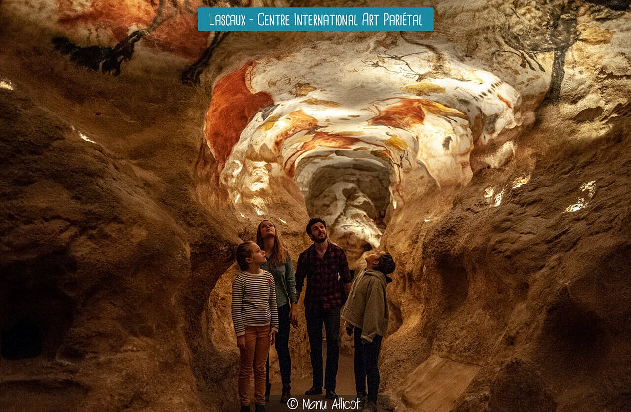 Famille admirant les peintures rupestres de la Grotte de Lascaux en Dordogne.