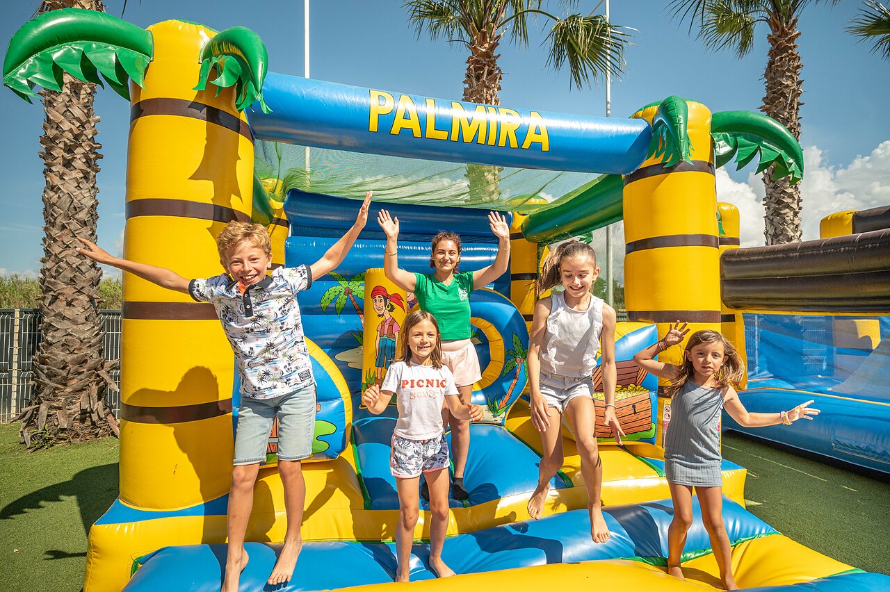 Enfants joyeux sautant sur structure gonflable PALMIRA au camping CLICOCHIC Palmira Beach � Vendres-Plage (34).
