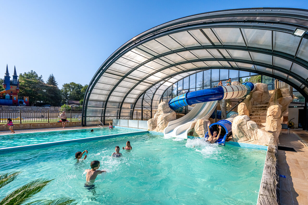 Piscine couverte avec toboggans aquatiques et enfants jouant au camping CAPFUN Palombi�re � Sarlat (24).