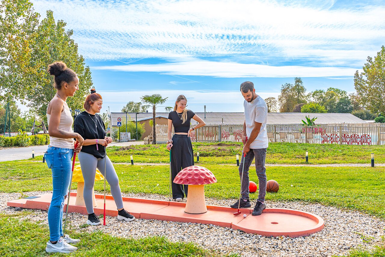 Mini-golf avec des amis jouant sur le parcours au camping CAPFUN Parc de Paris � Villevaud� (77).