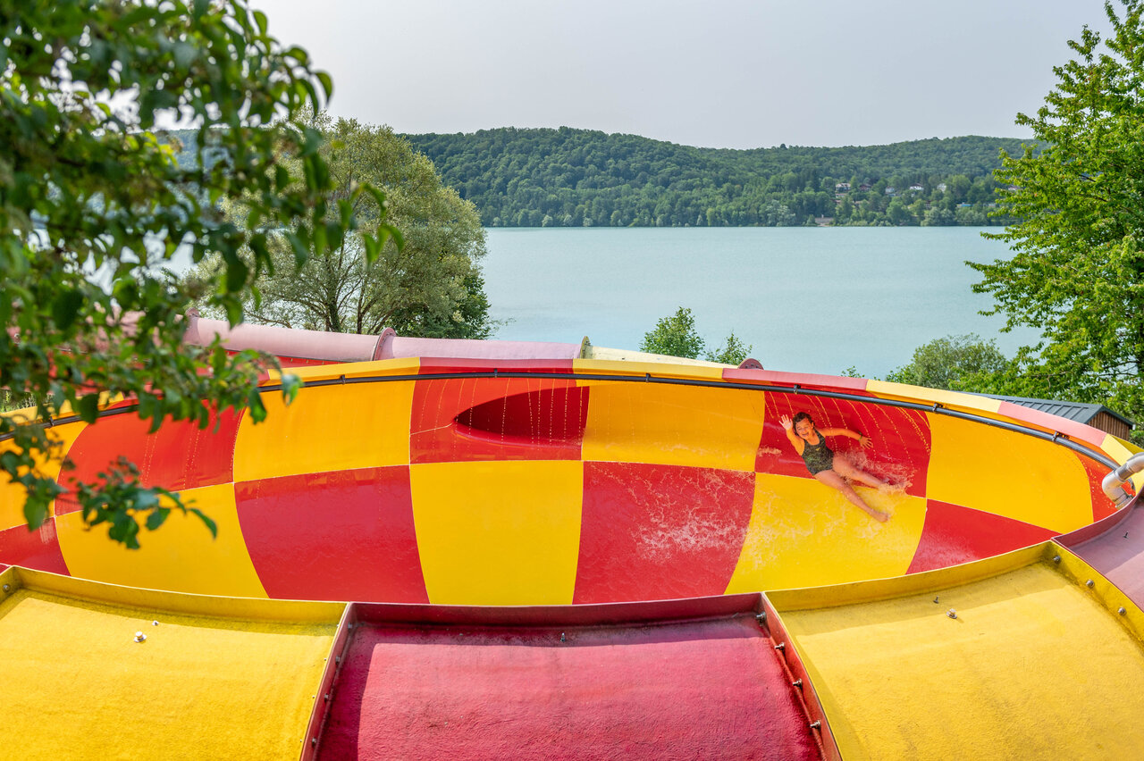 Enfant glissant sur toboggan aquatique g�ant, vue lac, camping CAPFUN Pergola Marigny (39).